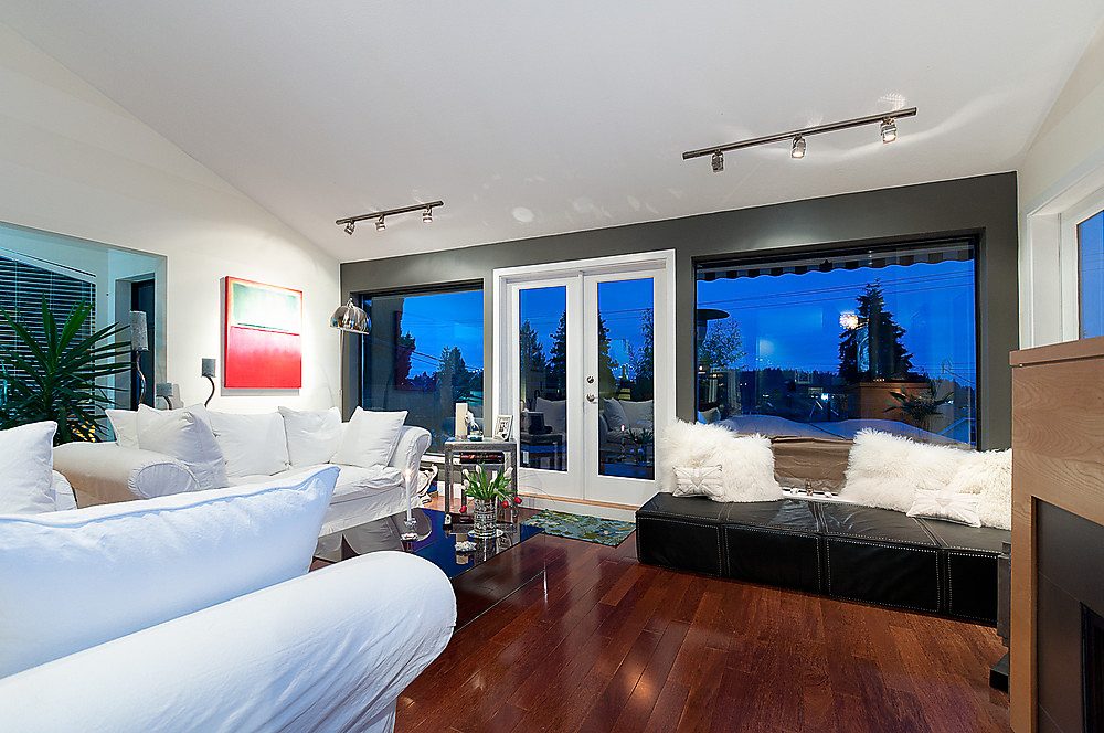 Furnished living room with hardwood floors, city view, and modern decor. - 1119 Keith Road, West Vancouver