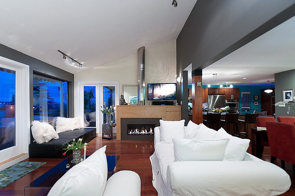 Spacious living room with hardwood floors, modern fireplace, and city view. - 1119 Keith Road, West Vancouver