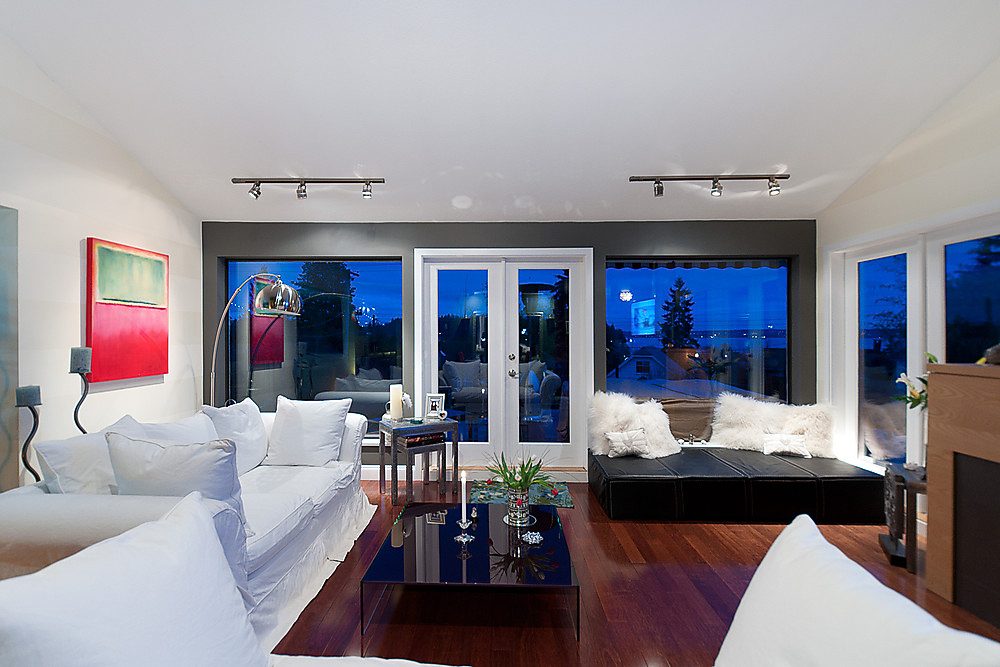 Furnished living room with hardwood floors, modern furniture, and city view windows. - 1119 Keith Road, West Vancouver