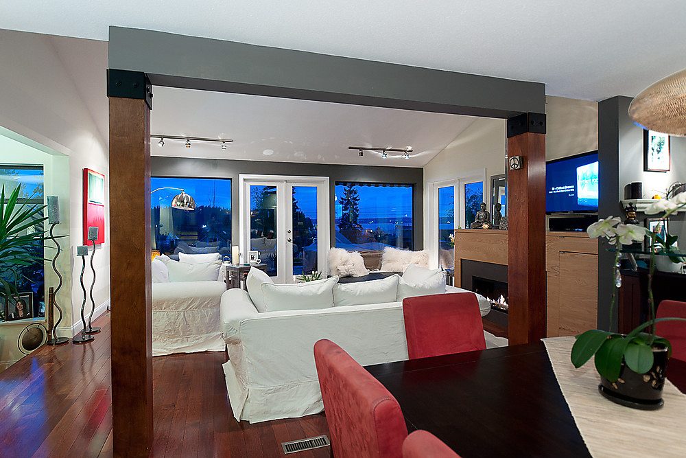 Furnished living room with hardwood floors, city view, and modern decor. - 1119 Keith Road, West Vancouver