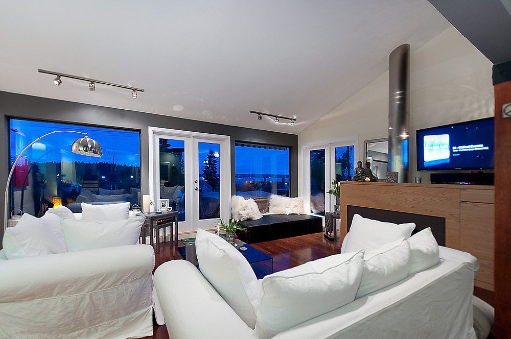 Furnished living room with hardwood floors, city view, and modern decor. - 1119 Keith Road, West Vancouver