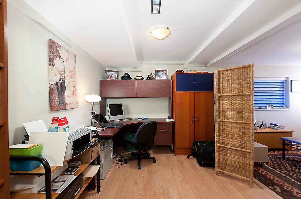 Furnished office with hardwood floors, desk, and storage cabinets. - 1119 Keith Road, West Vancouver