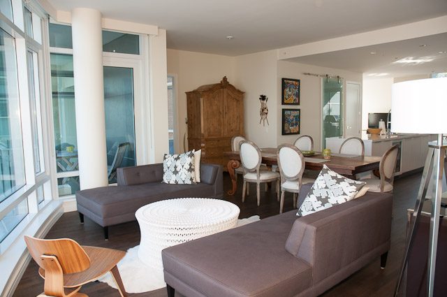 Spacious living room with large windows, modern furniture, and a view of the city. - 501-150 Athletes Way, Vancouver West Side
