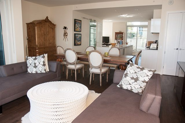 Bright living room with hardwood floors, modern furniture, and a city view. - 501-150 Athletes Way, Vancouver West Side