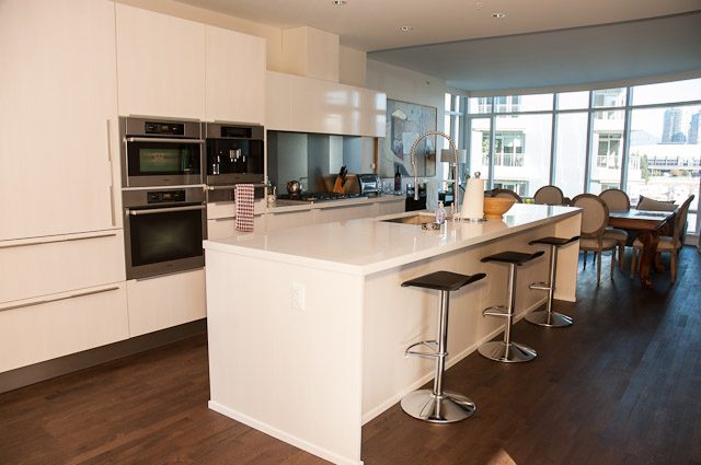Bright kitchen with white countertops, hardwood floors, and a city view. - 501-150 Athletes Way, Vancouver West Side