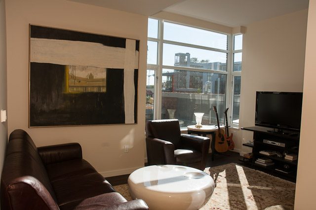 Furnished living room with large windows, city view, and modern decor. - 501-150 Athletes Way, Vancouver West Side