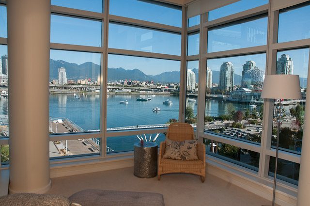 Bright living room with panoramic city view and waterfront, furnished with modern decor. - 501-150 Athletes Way, Vancouver West Side