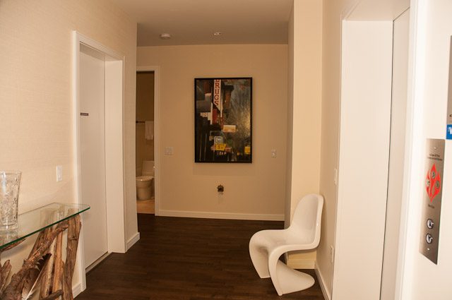 Bright dining area with modern decor, white chairs, and dark wood table. - 501-150 Athletes Way, Vancouver West Side