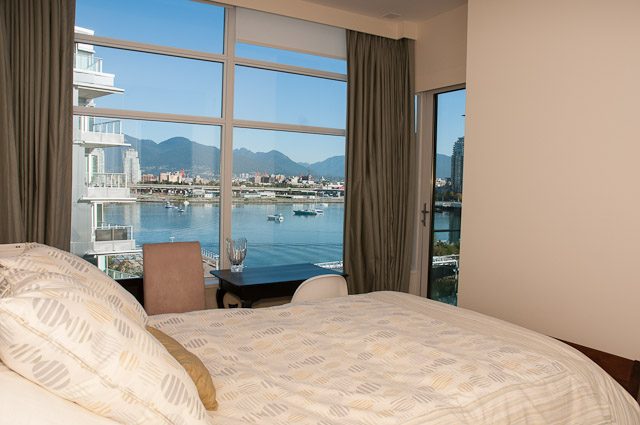 Spacious bedroom with a stunning city view and large windows. - 501-150 Athletes Way, Vancouver West Side