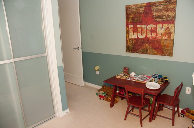Bright dining area with red chairs and a "LUCK" artwork on the wall. - 501-150 Athletes Way, Vancouver West Side