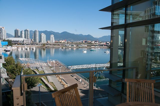 Bright living room with city view and modern furnishings. - 501-150 Athletes Way, Vancouver West Side
