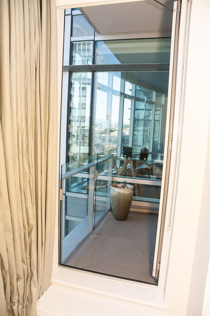 Bright living room with large windows and city view. - 501-150 Athletes Way, Vancouver West Side