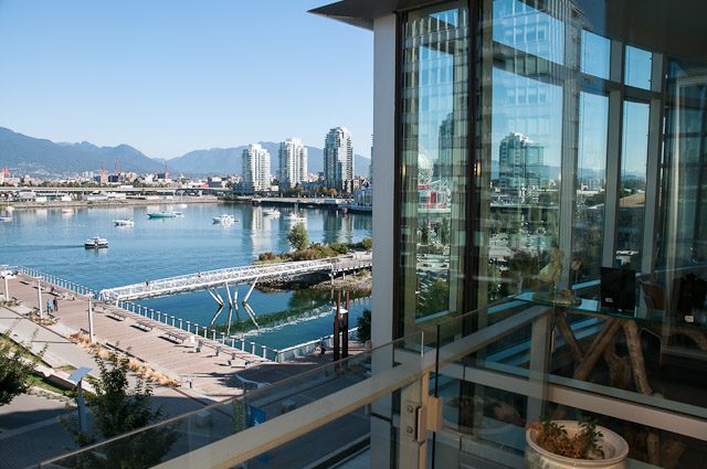 Bright living room with city view and modern furnishings. - 501-150 Athletes Way, Vancouver West Side