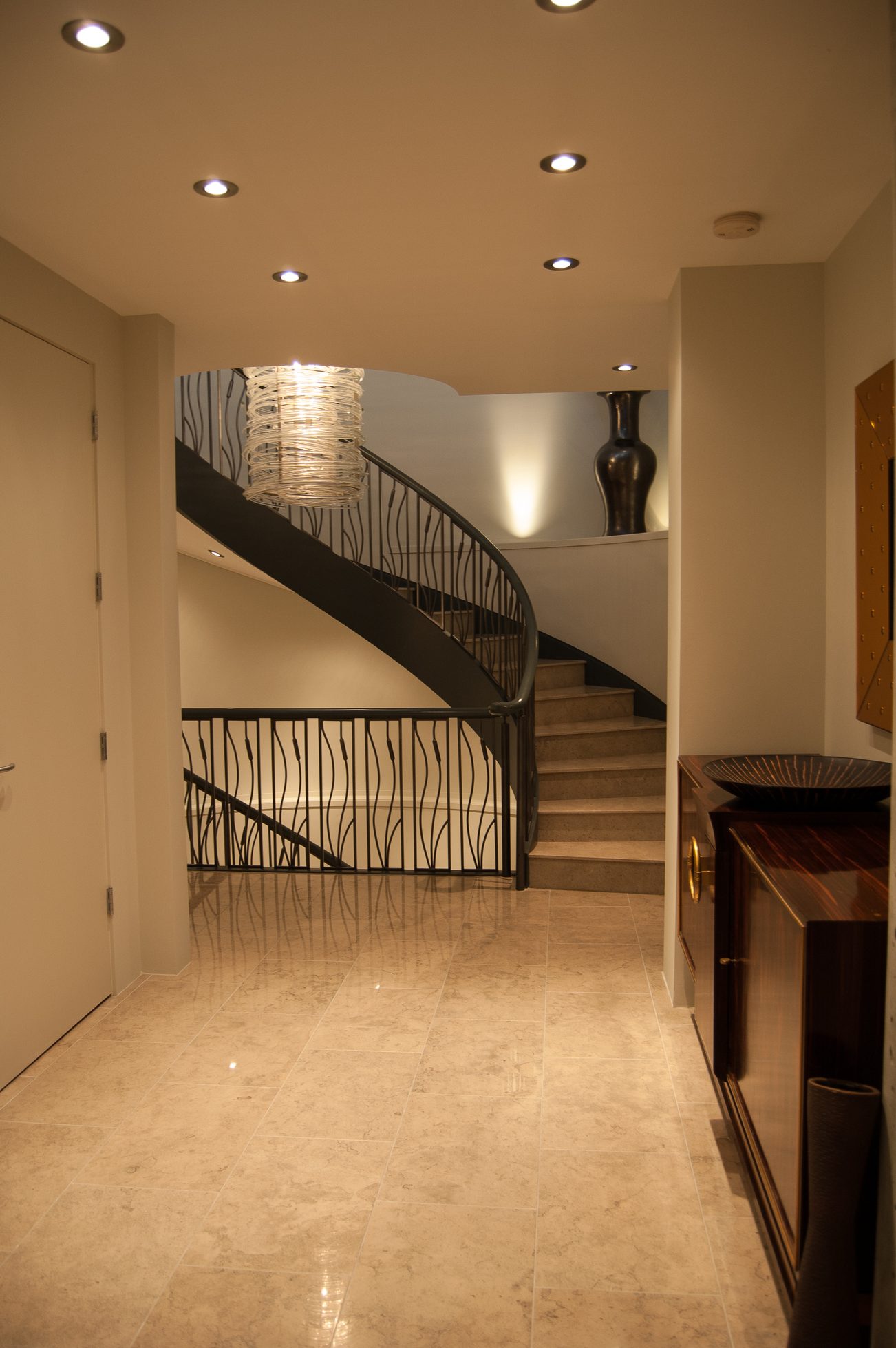 Elegant foyer with marble floors, curved staircase, and modern chandelier. - 4454 Regency Place, West Vancouver