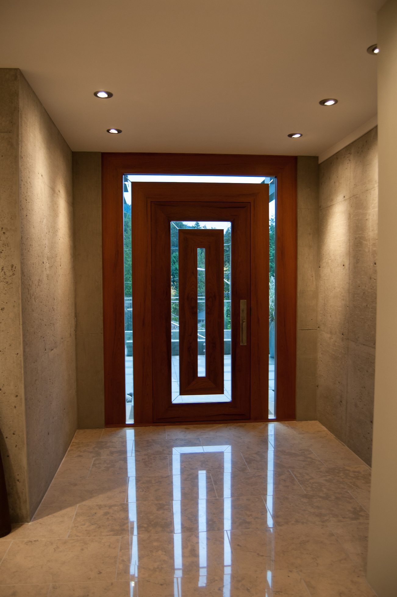 Foyer with polished marble floors and a wooden door leading to a scenic view. - 4454 Regency Place, West Vancouver