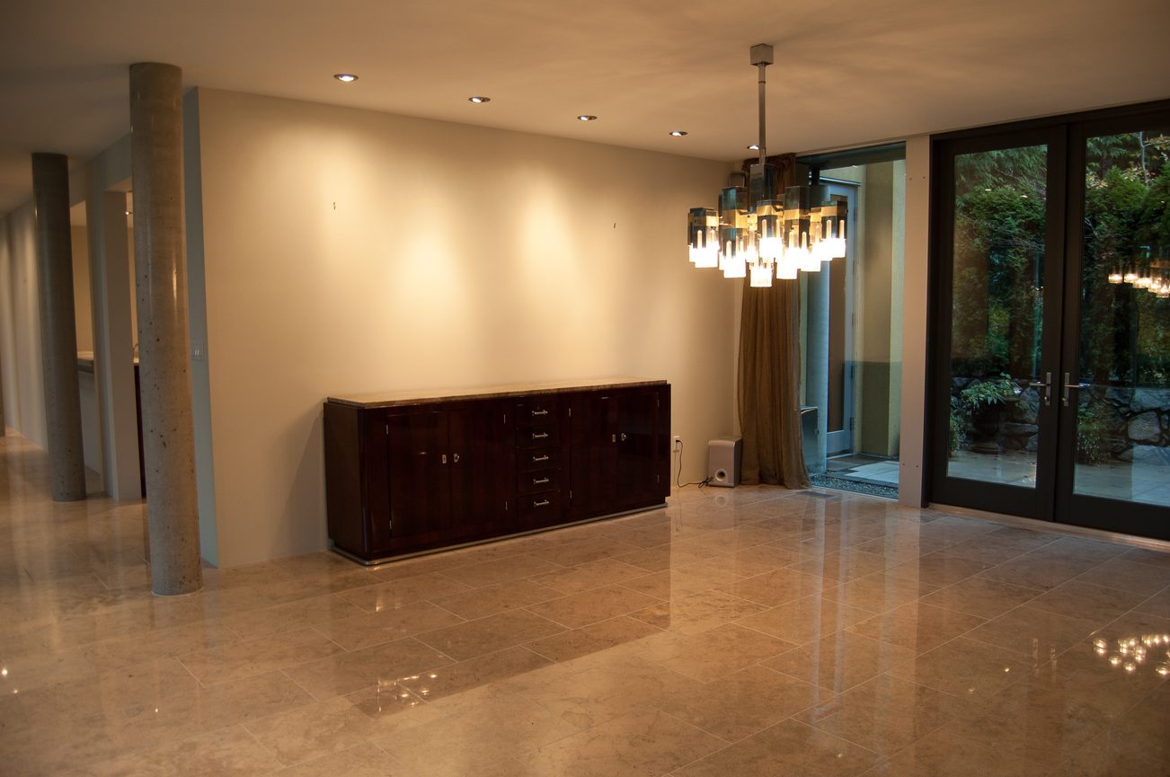 Foyer with marble floors, modern chandelier, and glass doors leading to outdoor garden. - 4454 Regency Place, West Vancouver