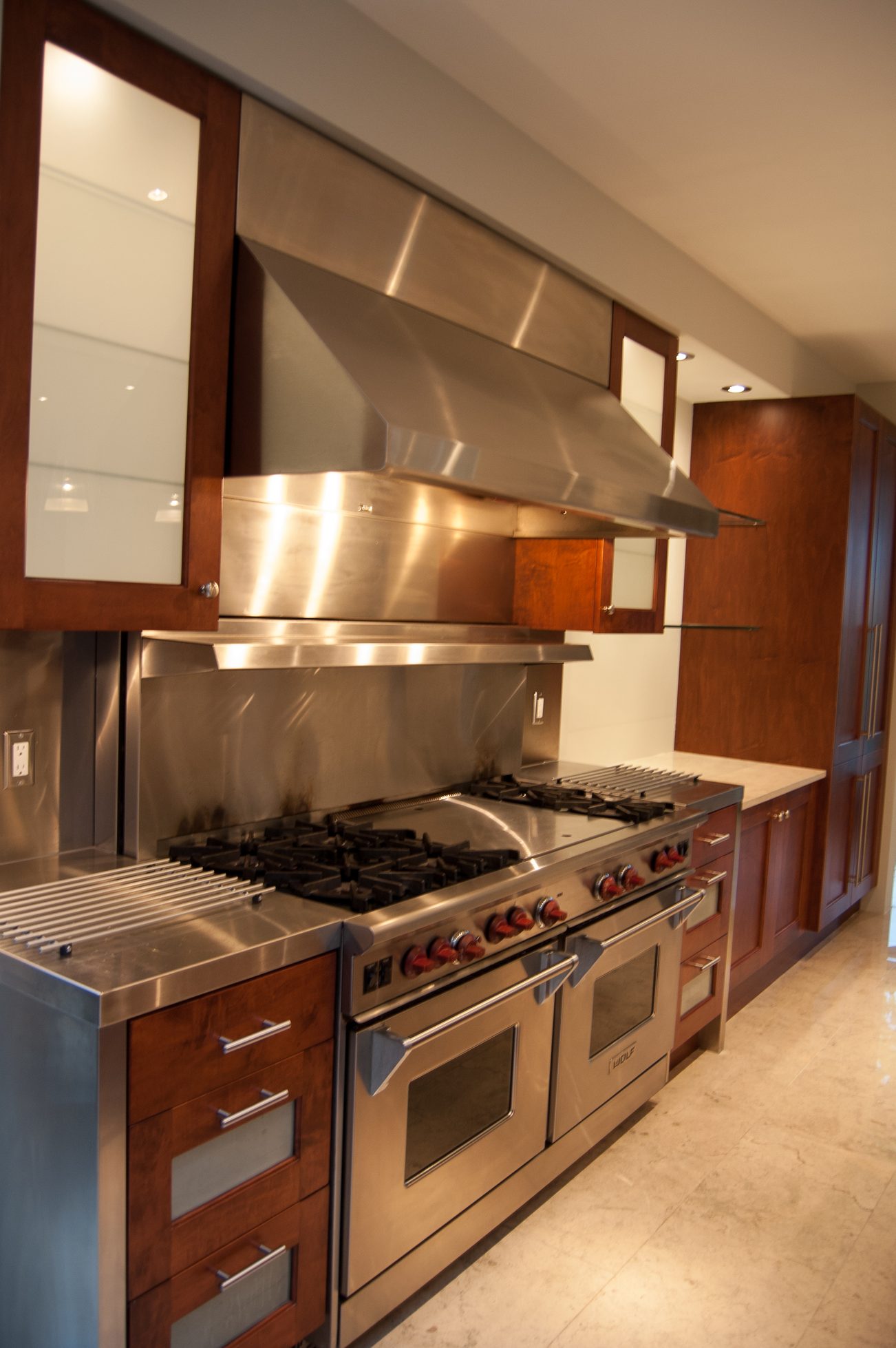 Bright kitchen with stainless steel appliances, granite countertops, and dark wood cabinetry. - 4454 Regency Place, West Vancouver