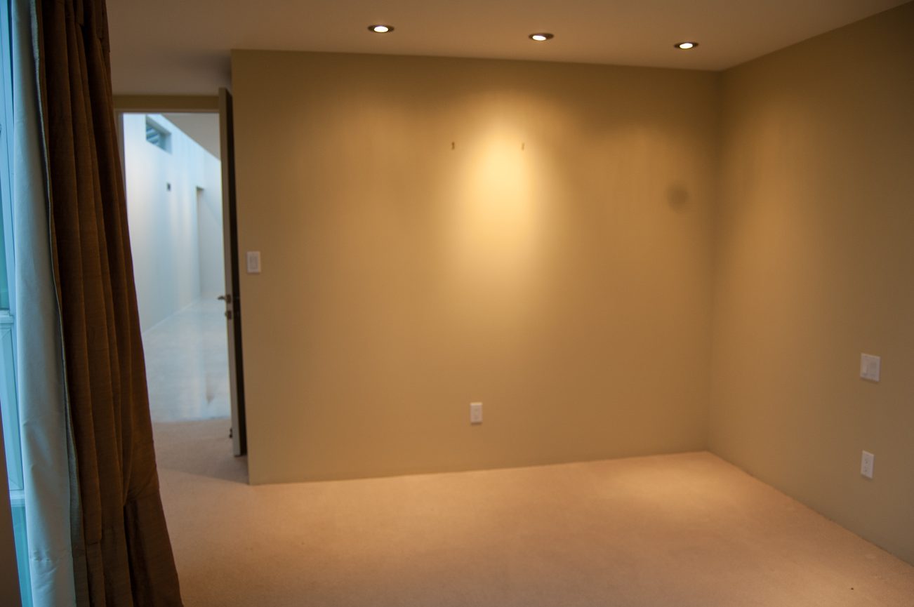 Spacious bedroom with beige walls and recessed lighting. - 4454 Regency Place, West Vancouver