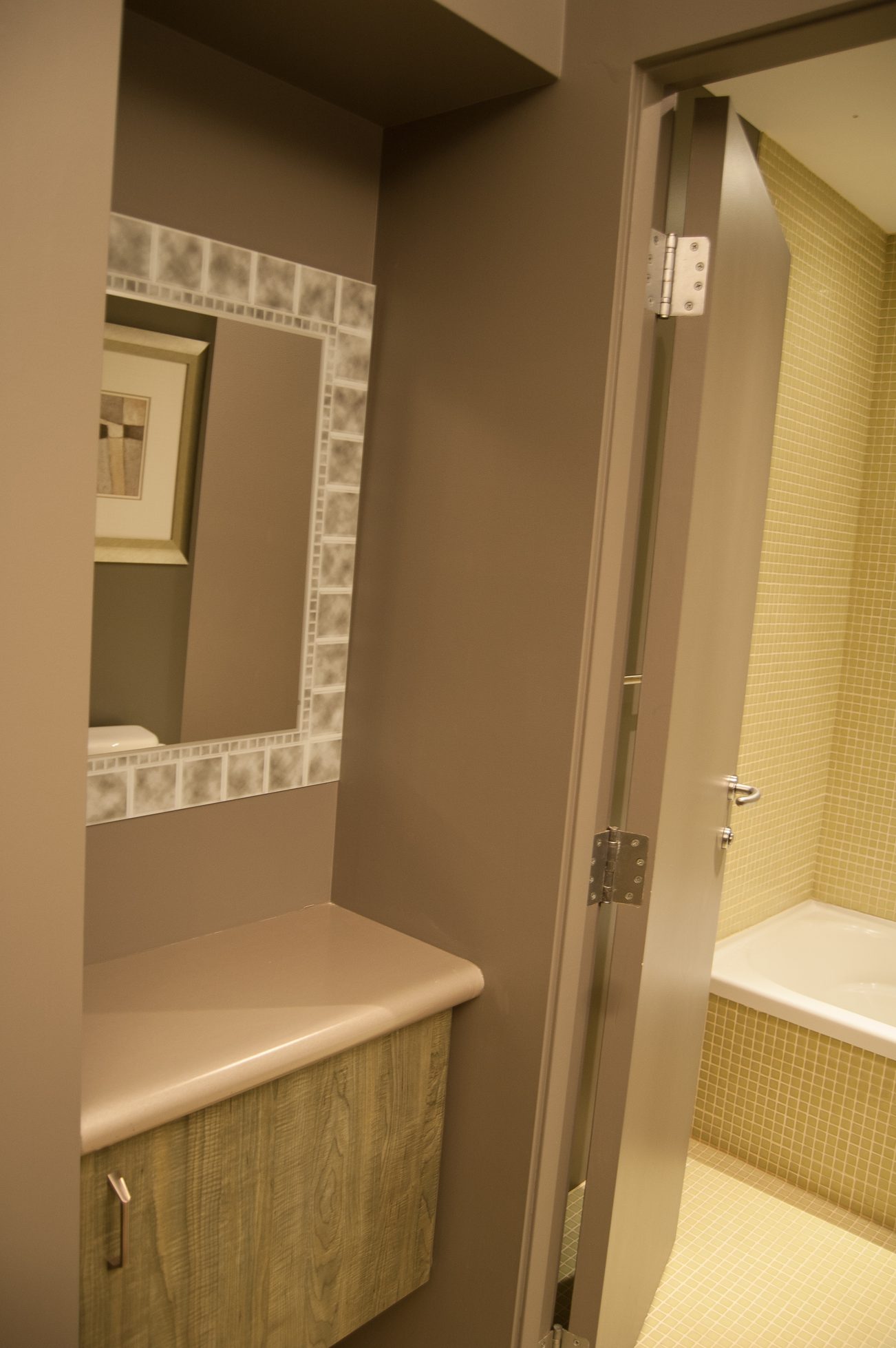 Bathroom with mosaic tile walls and a corner sink. - 4454 Regency Place, West Vancouver