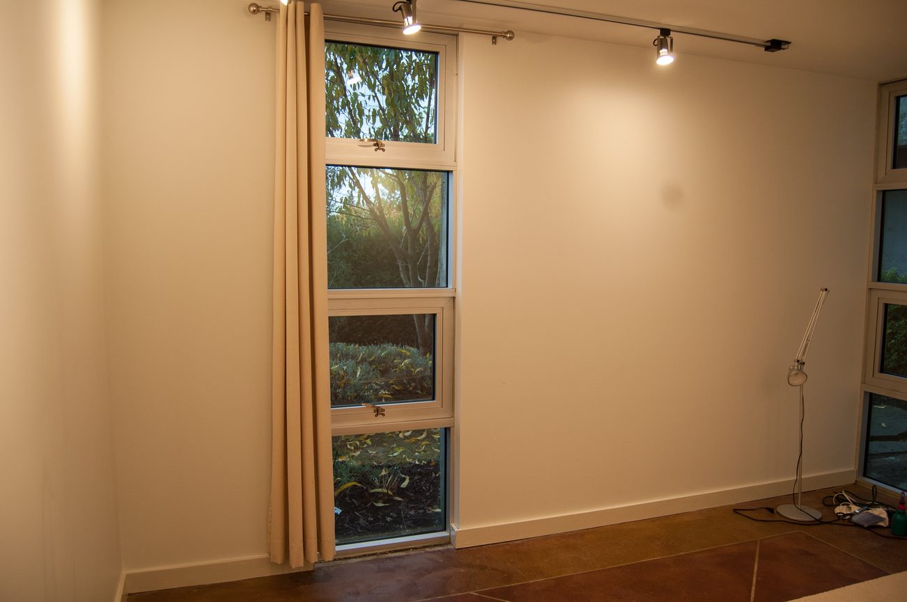 Bright living room with large windows, natural light, and a view of trees. - 4454 Regency Place, West Vancouver
