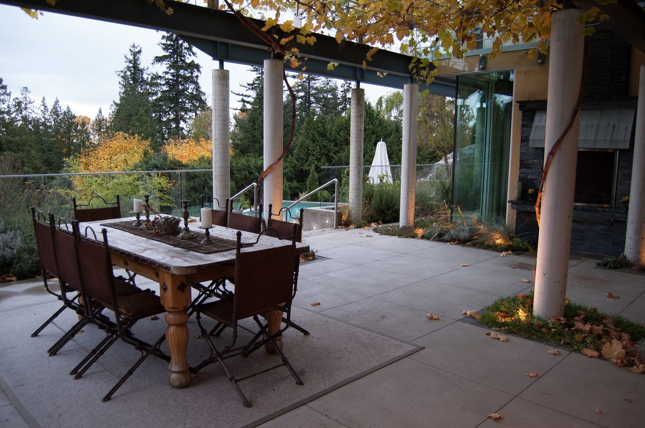 Furnished patio with outdoor dining set, fall foliage, and glass railings. - 4454 Regency Place, West Vancouver