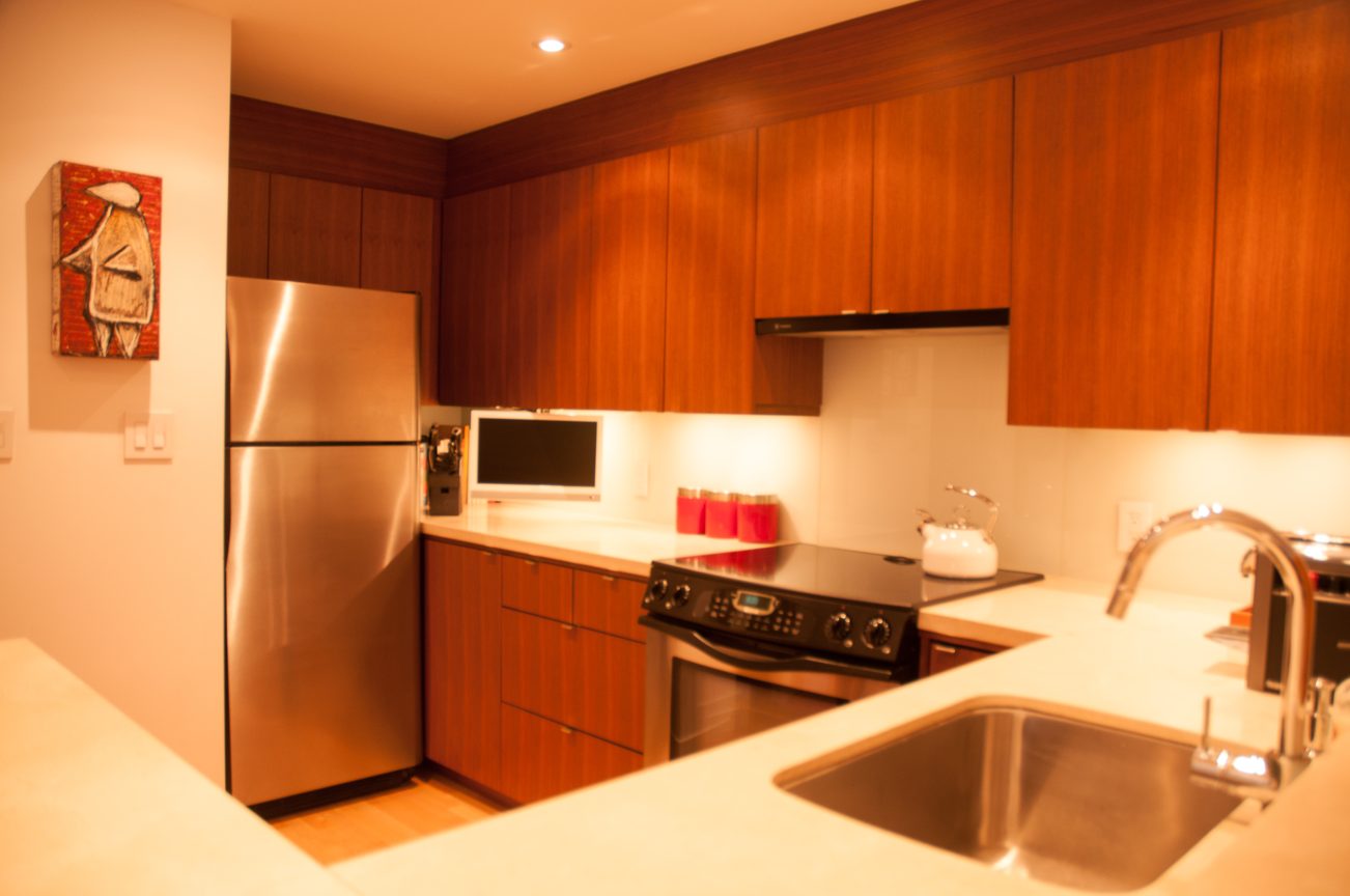 Bright kitchen with wood cabinets, stainless steel appliances, and a modern sink setup. - 7-2305 West 10th Ave, Vancouver West Side