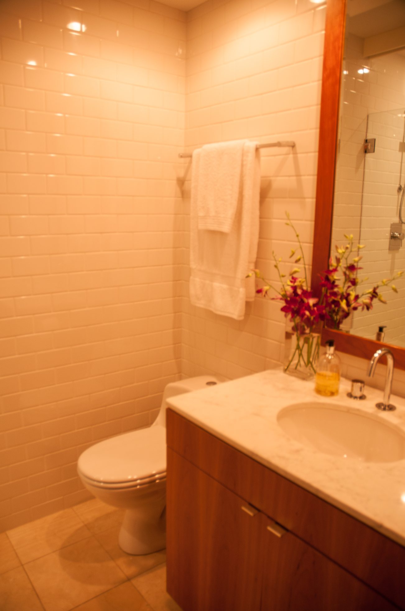 Furnished bathroom with white subway tiles, marble countertop, and wooden vanity. - 7-2305 West 10th Ave, Vancouver West Side