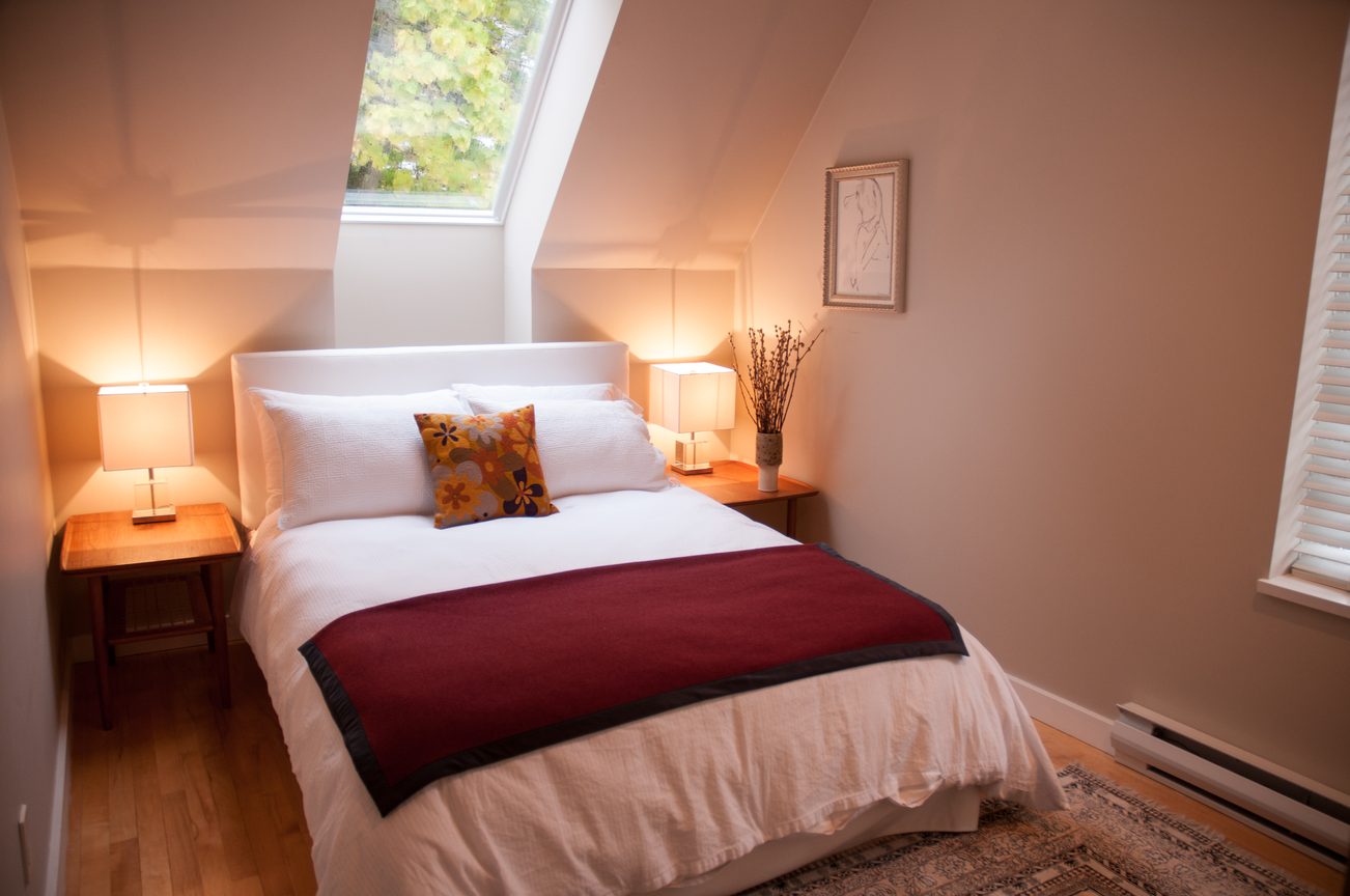 Bright bedroom with slanted ceiling, natural light, and wooden floors. - 7-2305 West 10th Ave, Vancouver West Side