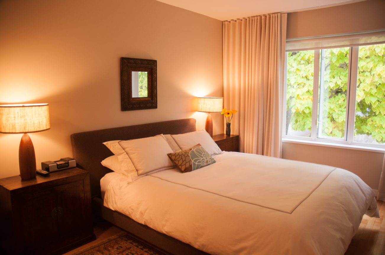 Furnished bedroom with cozy lighting and a view of greenery outside. - 7-2305 West 10th Ave, Vancouver West Side