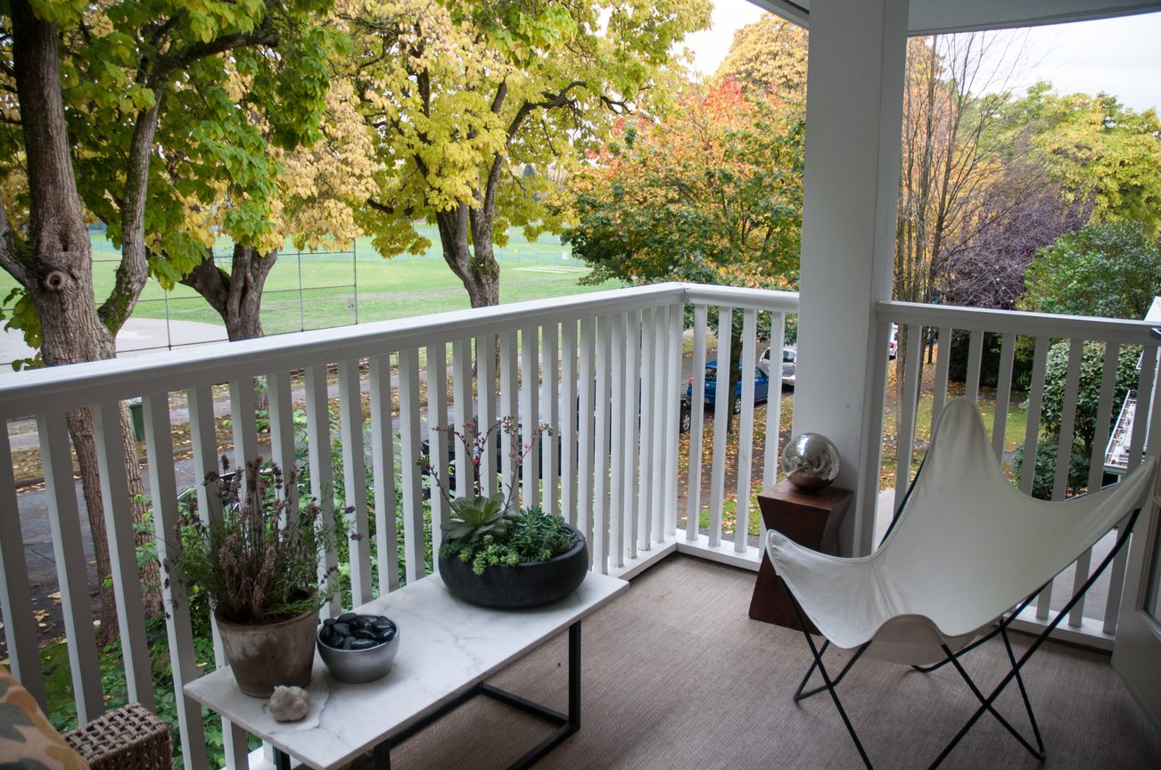 Furnished balcony with white railings, outdoor furniture, and autumn foliage view. - 7-2305 West 10th Ave, Vancouver West Side