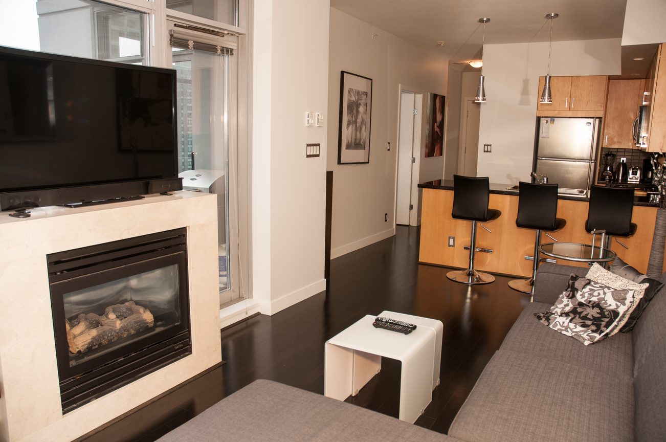 Bright living room with modern furnishings, fireplace, and city view. - 1406-1050 Smithe, Vancouver Downtown