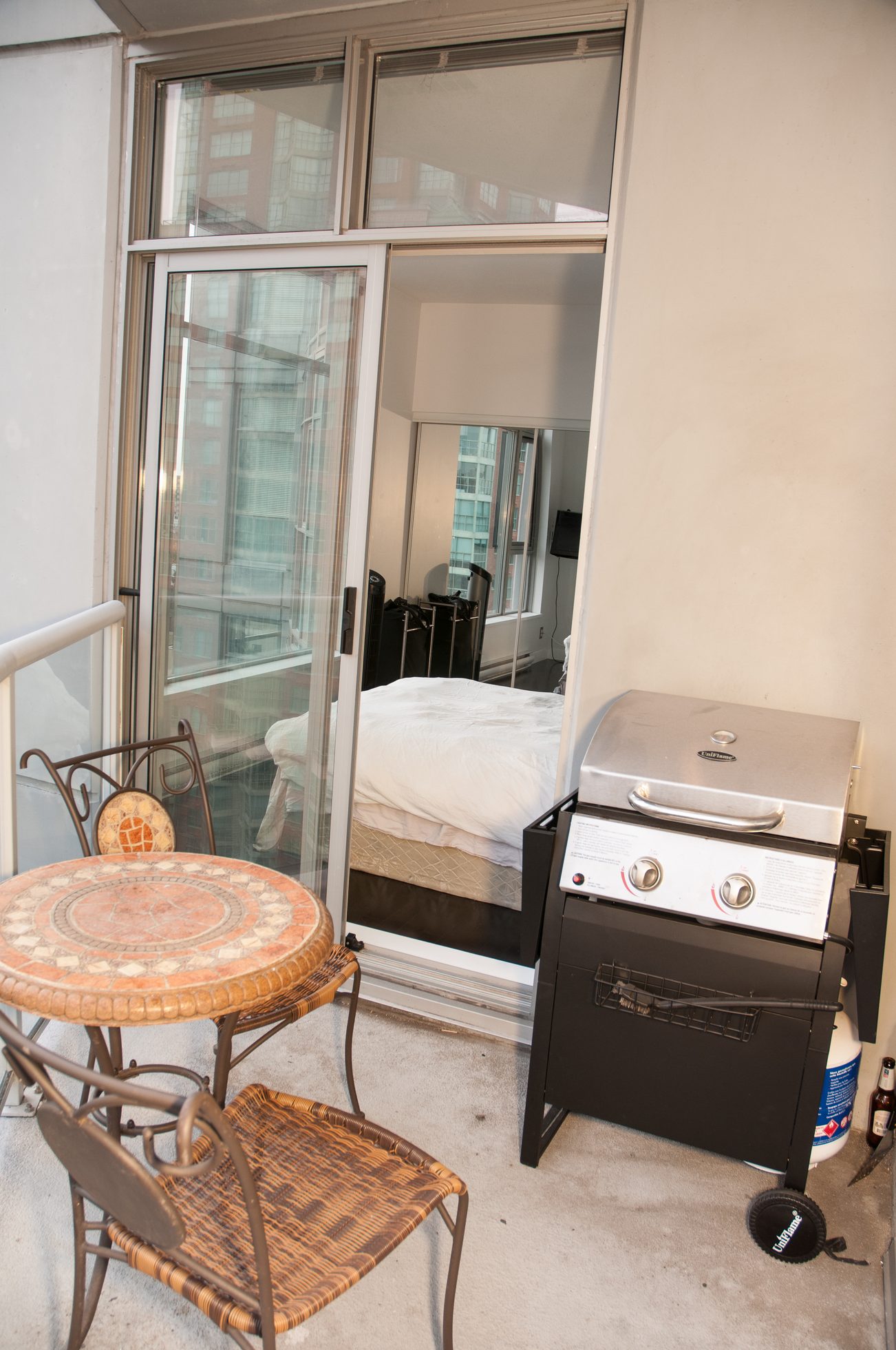 Bright balcony with sliding glass door, city view, and outdoor grill. - 1406-1050 Smithe, Vancouver Downtown