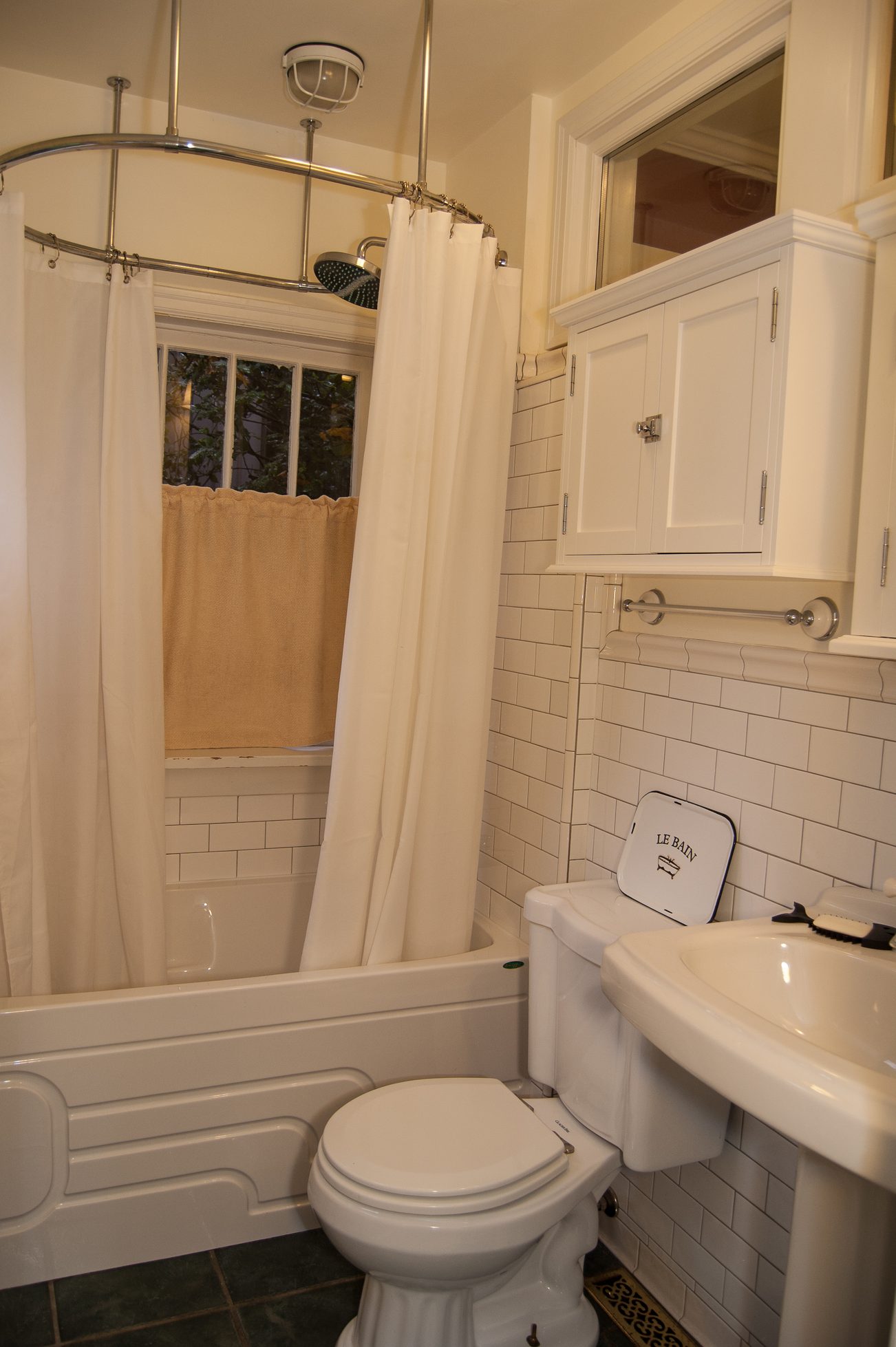 Furnished bathroom with white subway tiles and a curved shower. - 139 Osbourne Rd. East, North Vancouver