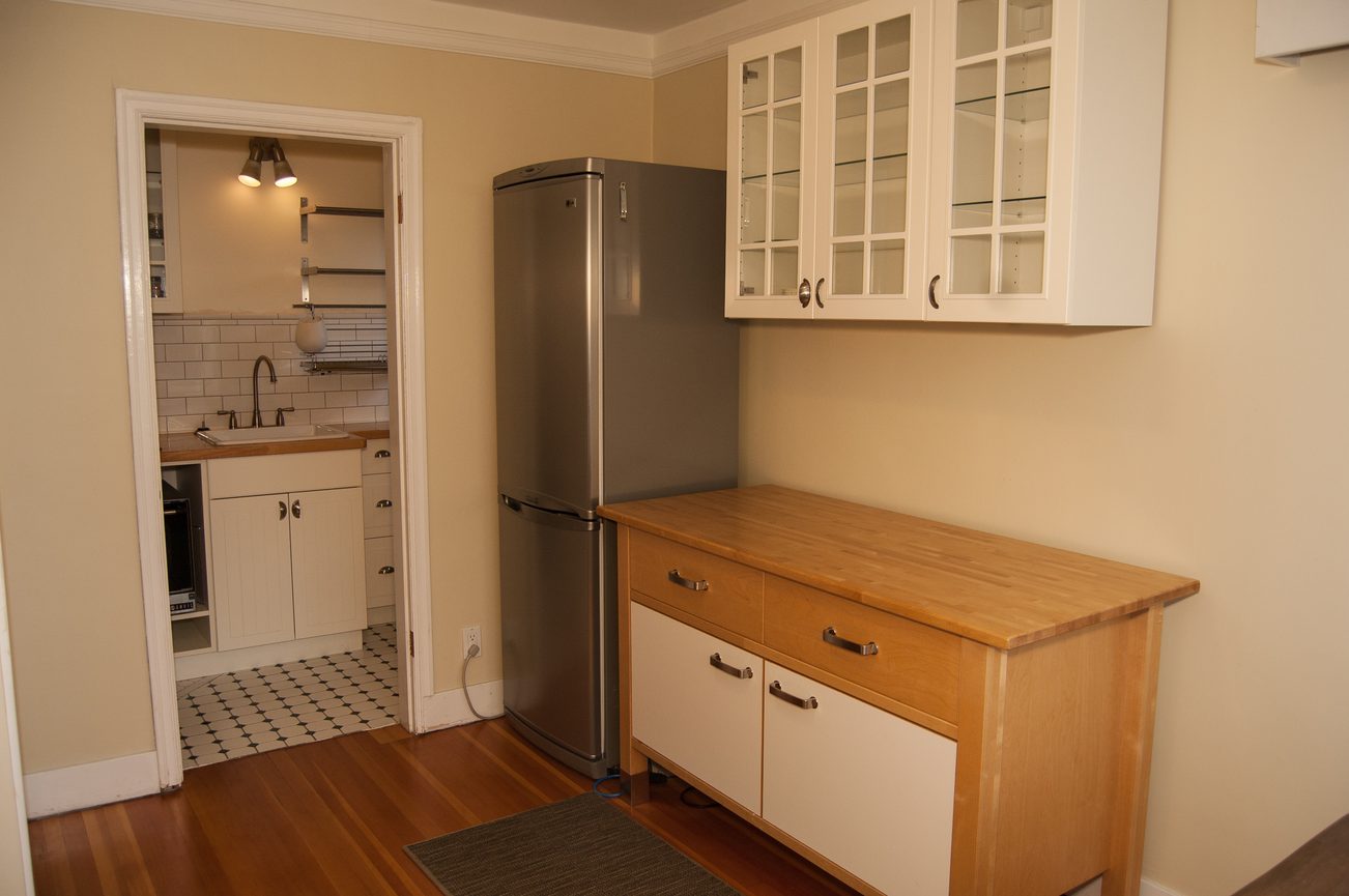 Bright kitchen with wooden countertops, hardwood floors, and a stainless steel refrigerator. - 139 Osbourne Rd. East, North Vancouver