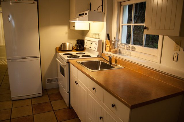 Bright kitchen with white appliances, wooden countertops, and a window view. - 139 Osbourne Rd. East, North Vancouver
