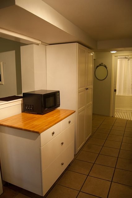 Bright kitchen with white cabinets, wooden countertop, and tiled floor. - 139 Osbourne Rd. East, North Vancouver
