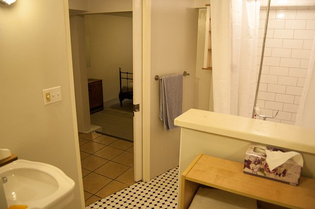 Bathroom with white subway tiles and wooden vanity. - 139 Osbourne Rd. East, North Vancouver