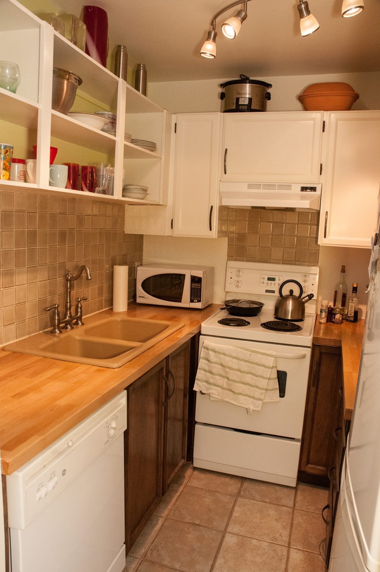 Bright kitchen with wooden countertops, white appliances, and a small stove. - 104 - 575 W 13th Ave, Vancouver West Side