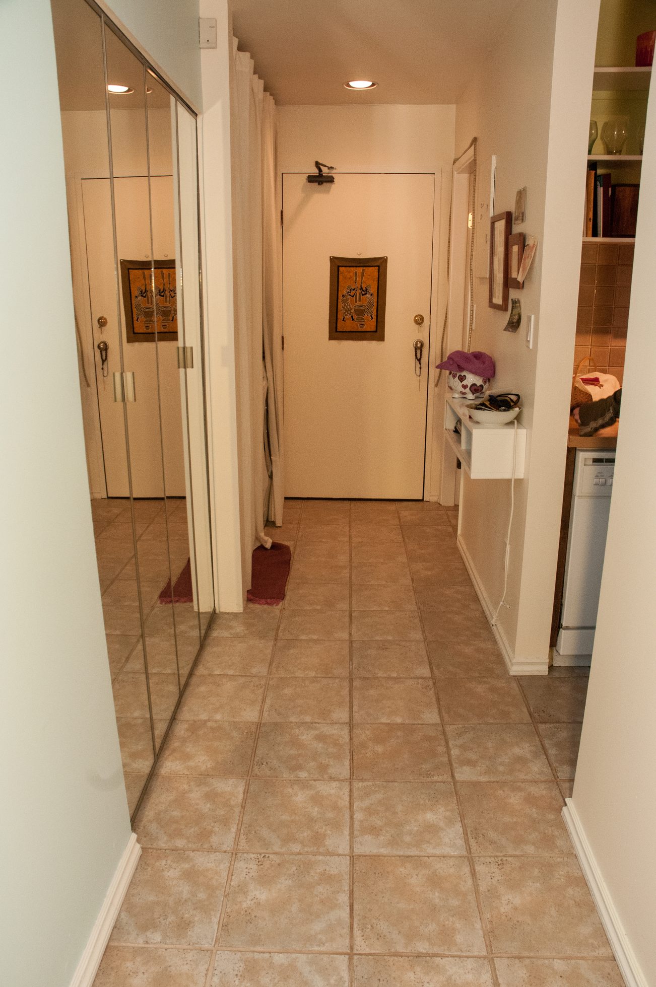 Furnished hallway with tiled floors and a sliding glass door leading to another room. - 104 - 575 W 13th Ave, Vancouver West Side