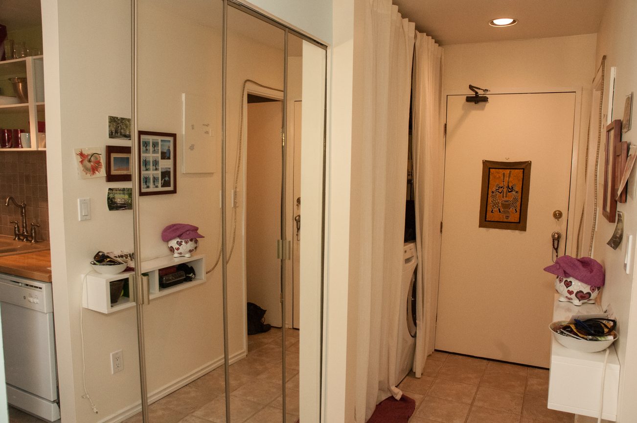 Bright kitchen with white cabinets, granite countertops, and a sliding door leading to a laundry area. - 104 - 575 W 13th Ave, Vancouver West Side
