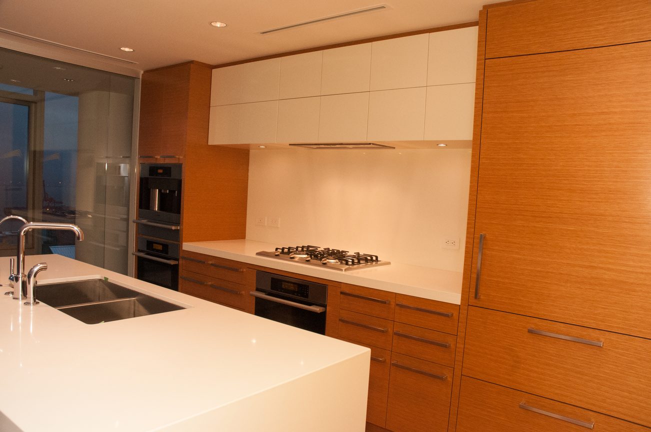 Bright kitchen with white countertops and wooden cabinets, featuring a gas stove and modern appliances. - 3102 - 667 Howe Street, Vancouver Downtown