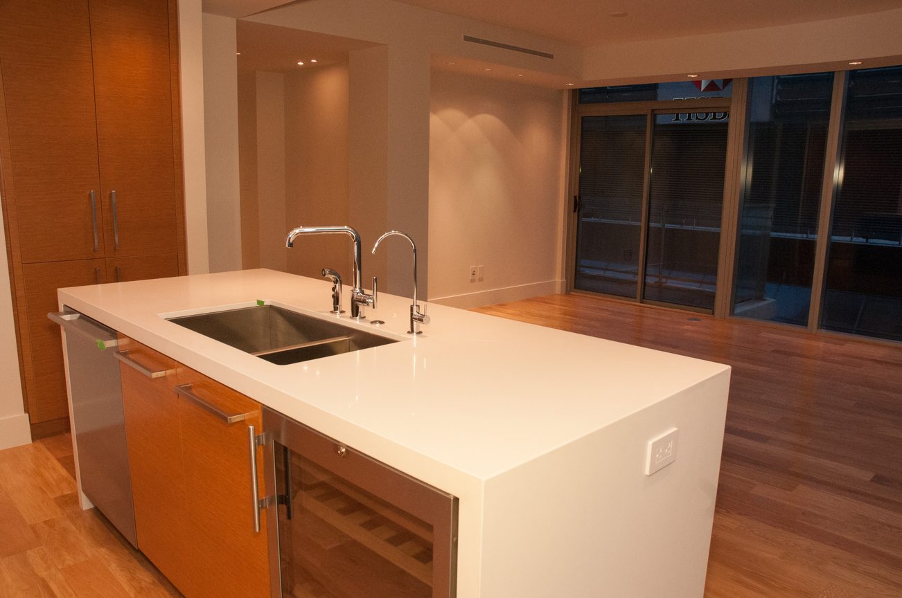 Bright kitchen with white countertops, stainless steel sink, hardwood floors, and city view. - 3102 - 667 Howe Street, Vancouver Downtown