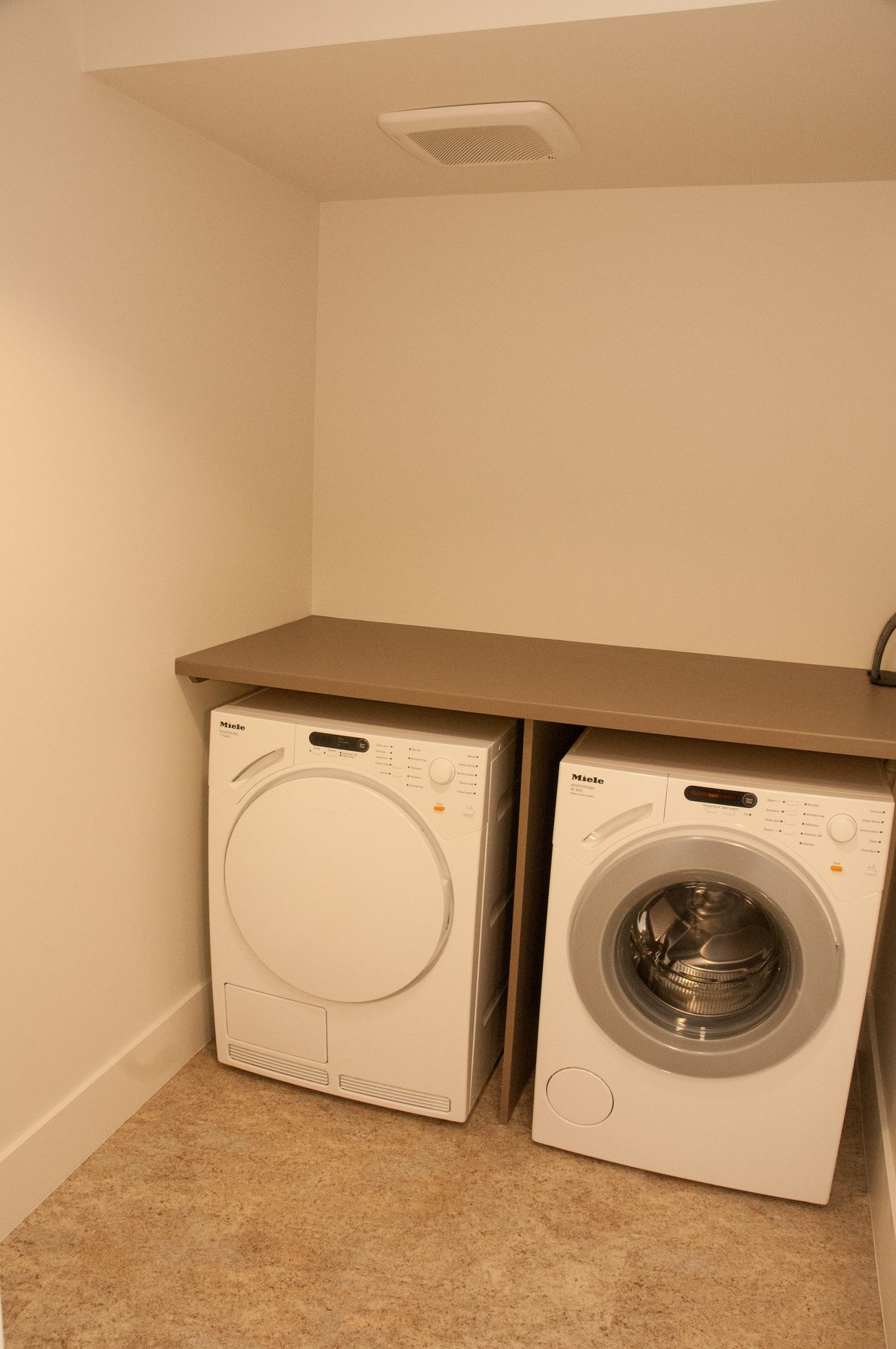 Laundry room with Miele washer and dryer, beige countertop. - 3102 - 667 Howe Street, Vancouver Downtown
