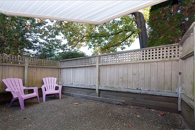Outdoor patio with purple Adirondack chairs and wooden railings. - 106-827 West 16th Street, North Vancouver