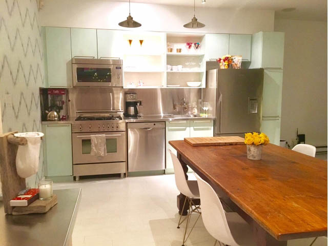 Bright kitchen with stainless steel appliances, wooden dining table, and modern decor. - 410 - 1072 Hamilton Street, Vancouver Downtown
