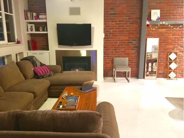 Furnished living room with brick wall, modern furniture, and a cozy fireplace. - 410 - 1072 Hamilton Street, Vancouver Downtown