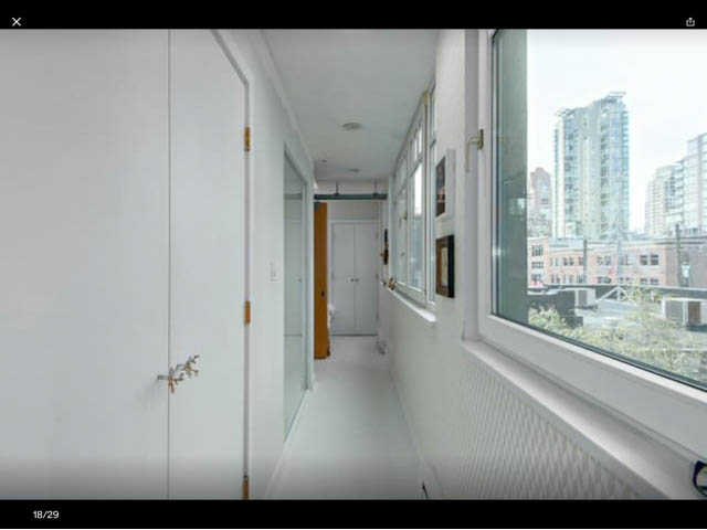 Bright living room with large windows offering a city view and modern furnishings. - 410 - 1072 Hamilton Street, Vancouver Downtown