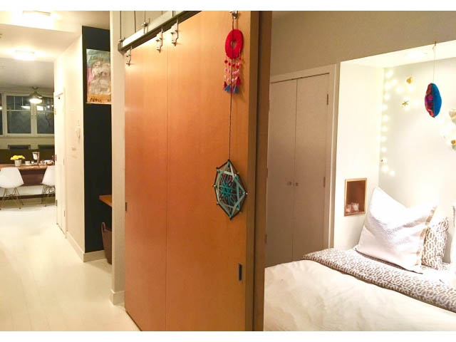Furnished 2-bedroom condo with wooden walls, dreamcatcher decor, and a cozy bedroom setup. - 410 - 1072 Hamilton Street, Vancouver Downtown