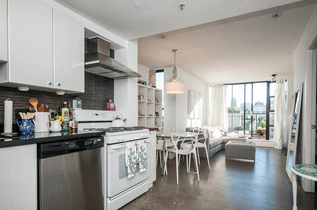 Bright kitchen with stainless steel appliances and a city view. - 312 - 1630 West 1st Ave., Vancouver West Side