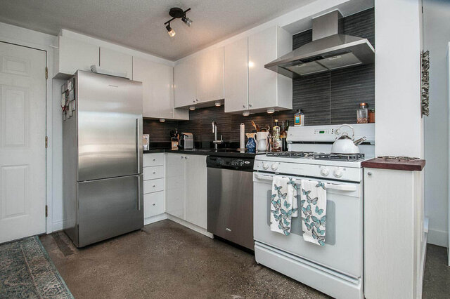 Bright kitchen with white cabinets, stainless steel appliances, and a gas stove. - 312 - 1630 West 1st Ave., Vancouver West Side